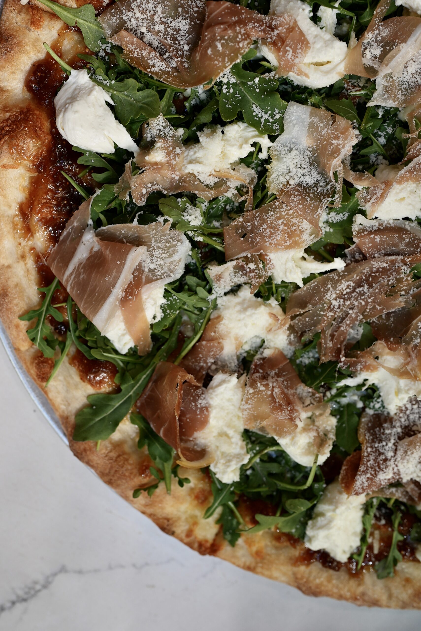 Closeup of Livoti's pizza with prosciutto and cheese