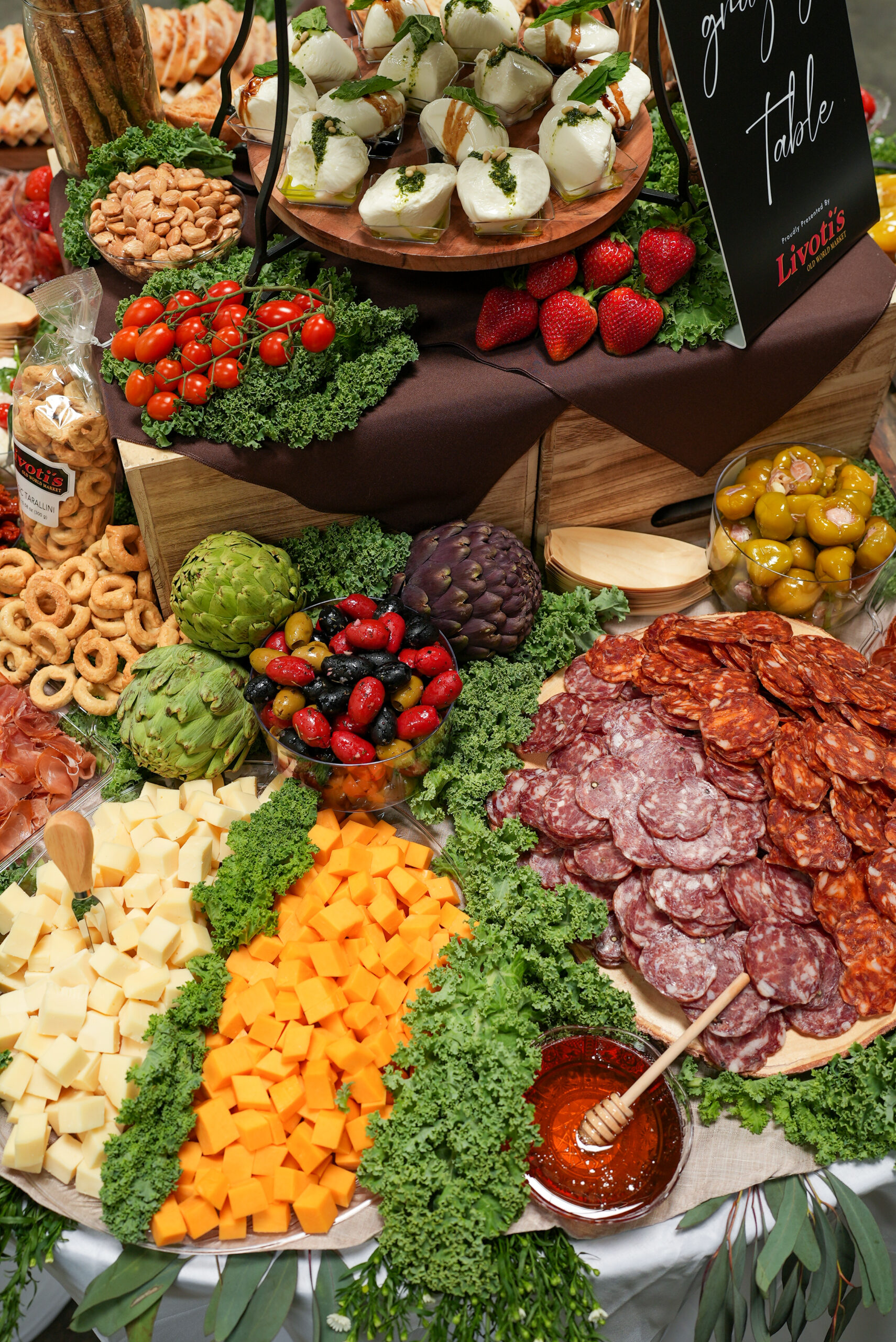 Livoti's Old World Market charcuterie display with meats, cheese, honey, olives, and more