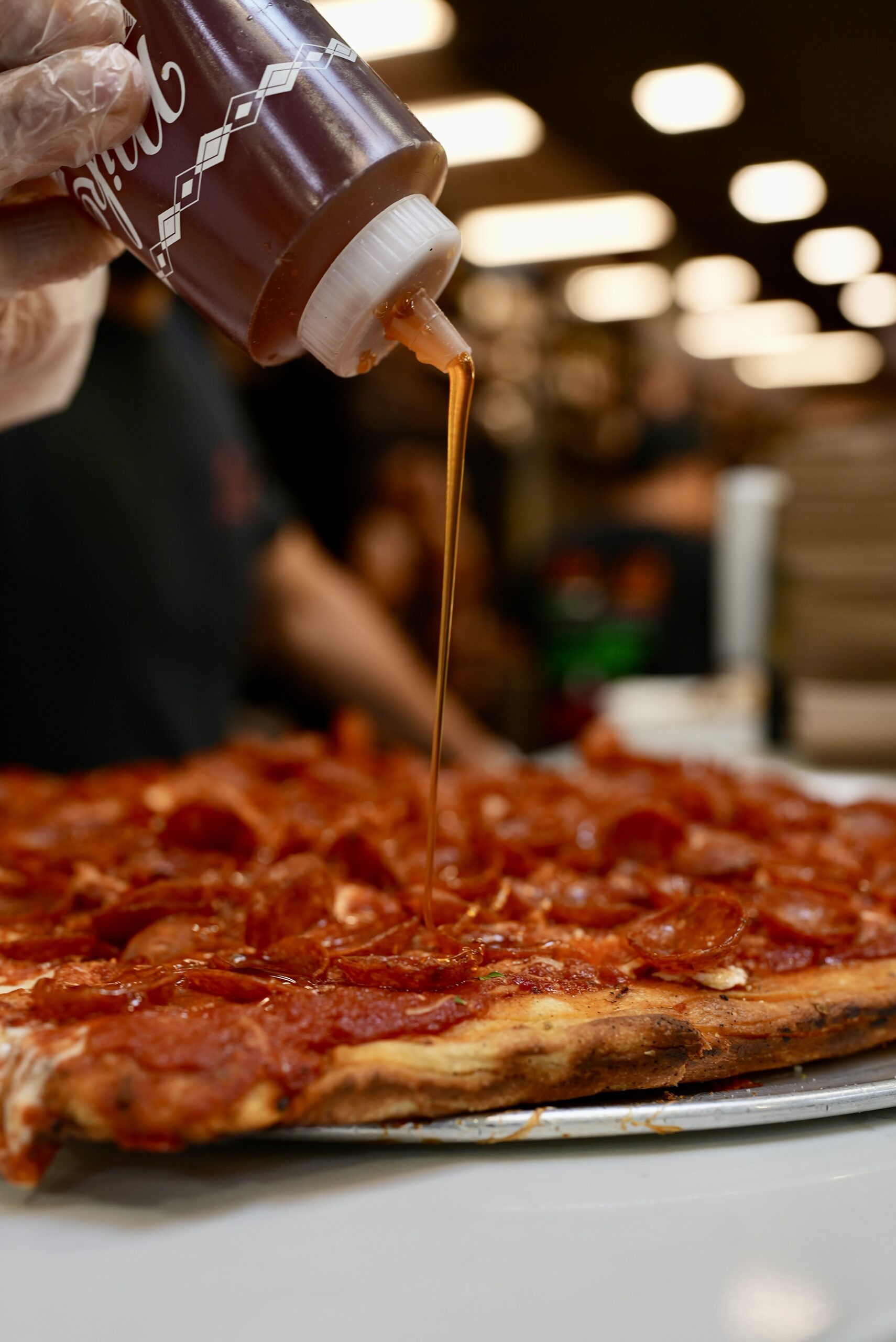 Drizzling hot honey on a Livoti's Old World Market pizza