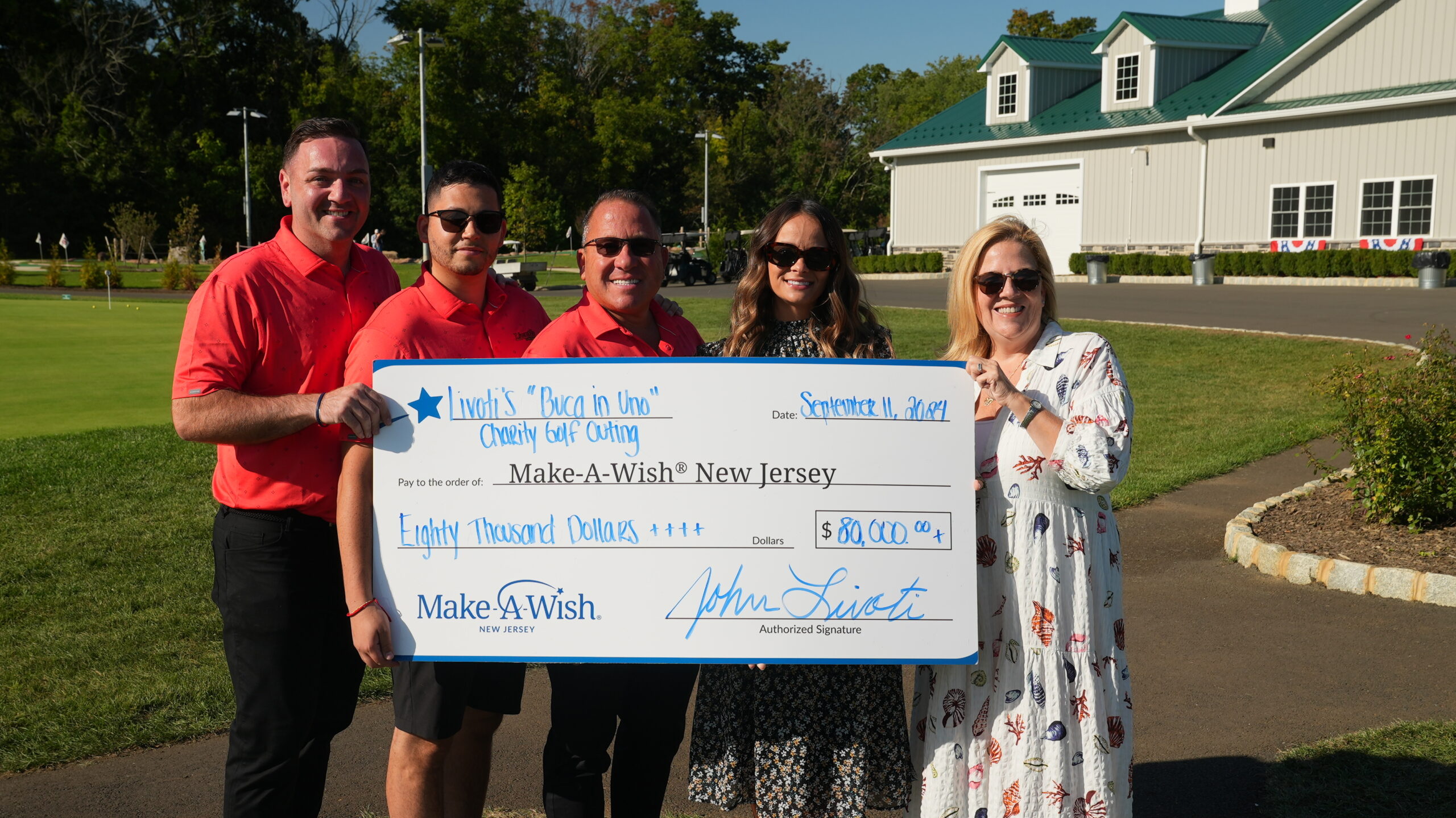 Livoti's Old World Market holding a large check written out to the Make-A-Wish Foundation of New Jersey